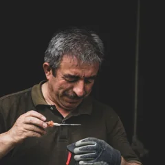 Artisan manipulant un outil à son établi — photo d’illustration