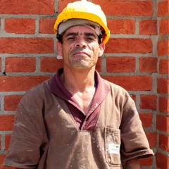 Homme portant un casque devant un mur de briques — photo d’illustration