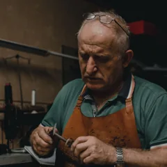Artisan avec lunettes manipulant un outil — photo d’illustration