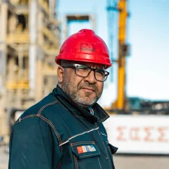 Homme portant un casque rouge sur un site industriel — photo d’illustration