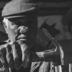 Artisan tenant un marteau, photographie en noir et blanc — photo d’illustration