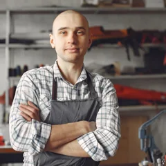 Artisan souriant portant un tablier dans son atelier — photo d’illustration